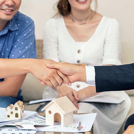 Shaking hands over model home